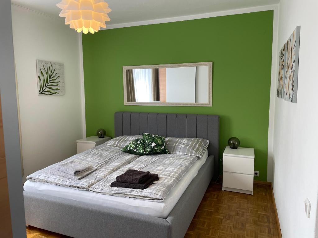 een slaapkamer met een bed met een groene muur bij Haus Graf Velden in Velden am Wörthersee