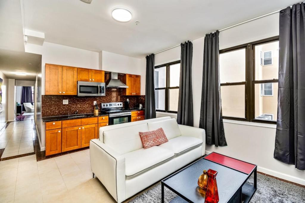 a living room with a white couch and a table at Be My Guest Gorgeous 2BD next to Reading Terminal in Philadelphia