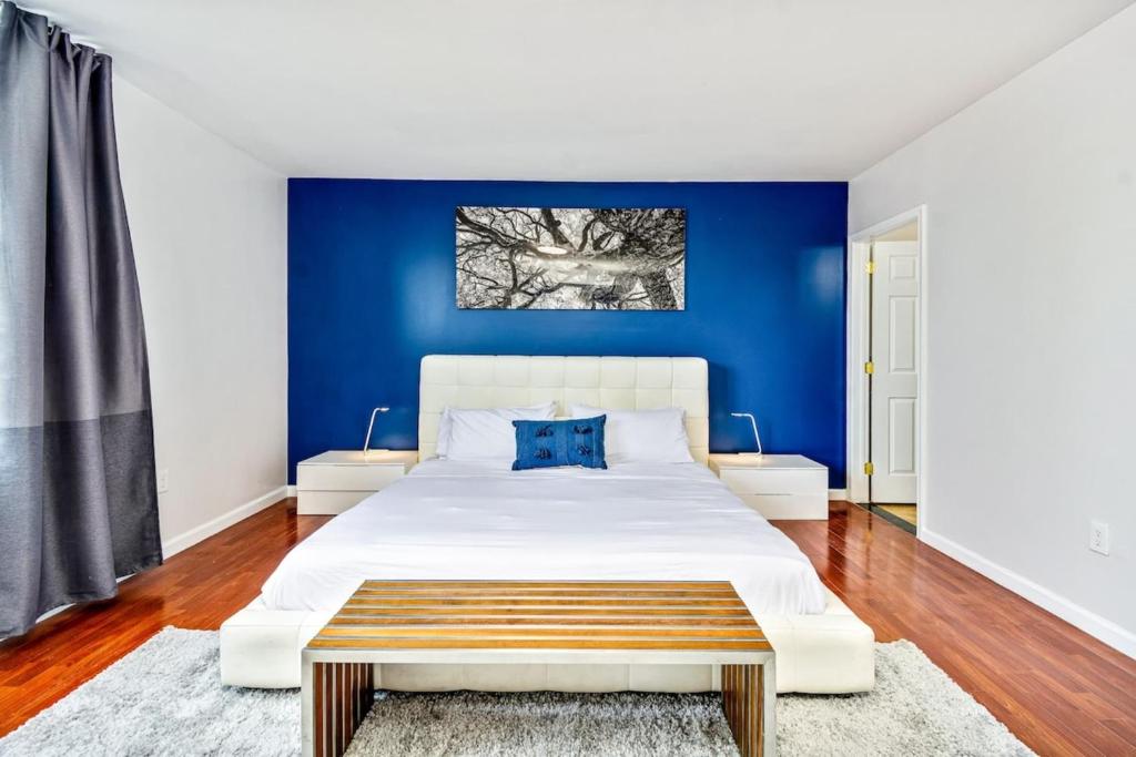 a bedroom with a large white bed with a blue wall at Be My Guest Gorgeous 2BD next to Reading Terminal in Philadelphia