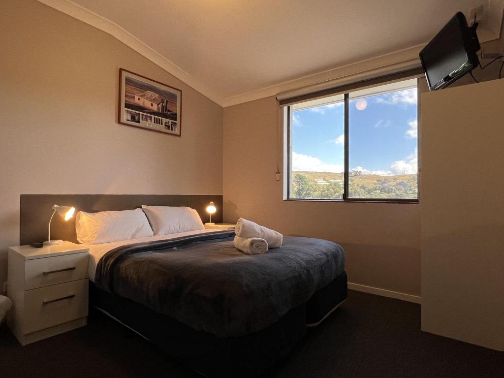 Un dormitorio con una cama grande y una ventana en Yuki Inn Jindabyne, en Jindabyne