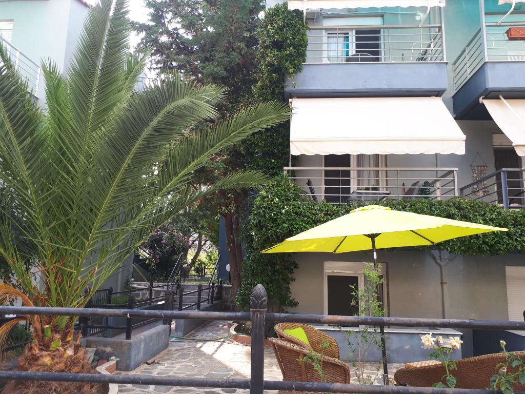 un paraguas amarillo sentado frente a un edificio en Fanari summer house 2 floors, en Fanárion