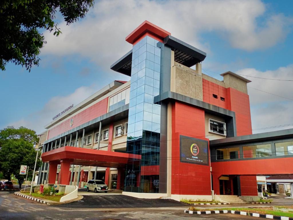 un edificio con un rosso e blu di UNP Hotel & Convention a Padang