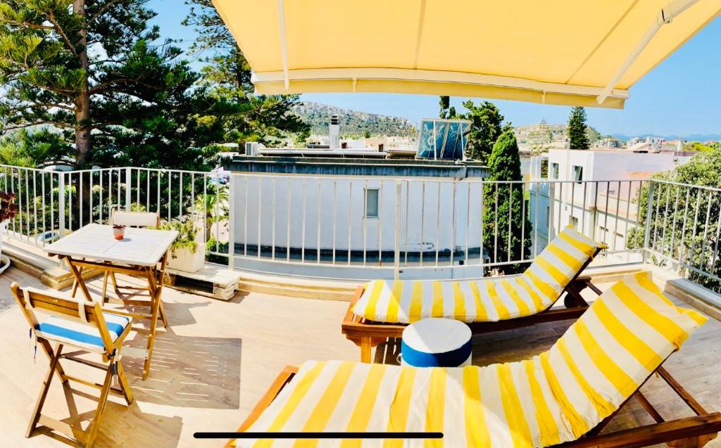 eine Terrasse mit Stühlen, einem Tisch und einem Sonnenschirm in der Unterkunft Il Profumo del Mare in Cagliari