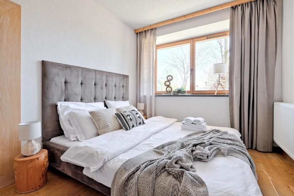 ザコパネにあるMonte House Apartments Odkryj Zakopaneのベッドルーム1室(大きなベッド1台、大きな窓付)