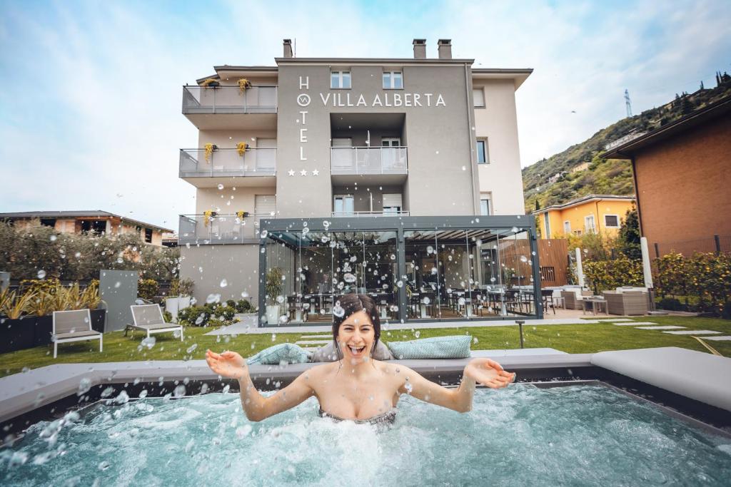 Eine Frau in einem Schwimmbad in einem Gebäude in der Unterkunft Hotel Villa Alberta in Nago-Torbole