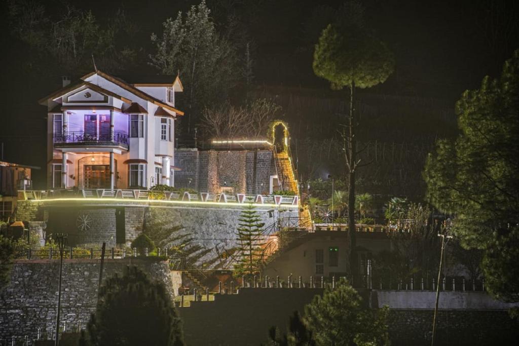 a house is lit up at night at Ram Cottage Chail 3 BHK villa with Lawn & Parking in Chail