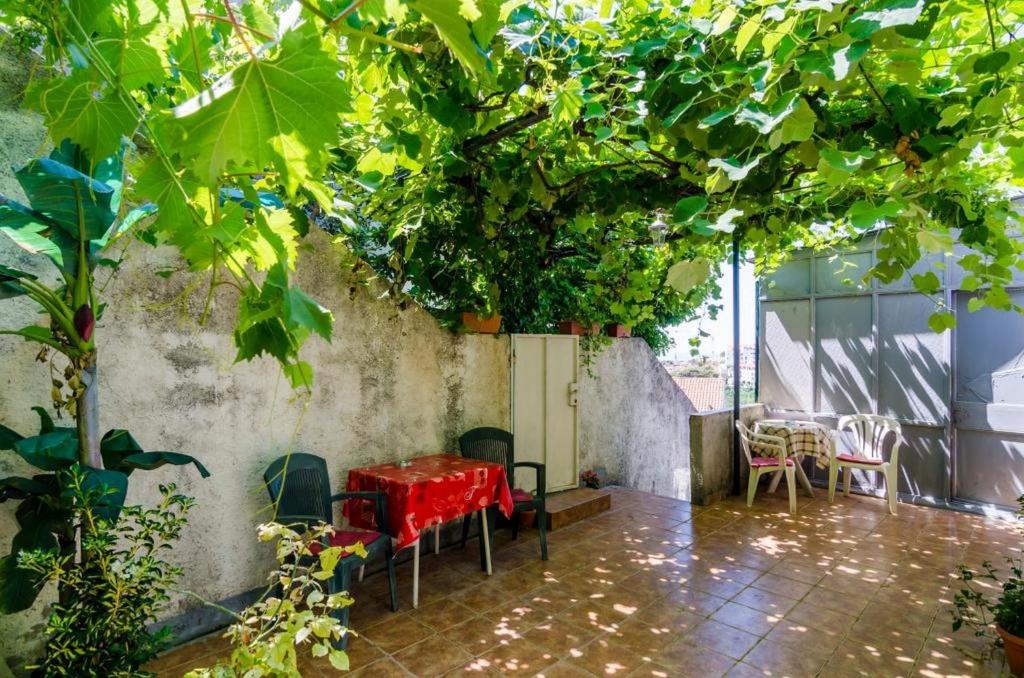 a patio with a red table and plants at Guest House Mara in Dubrovnik