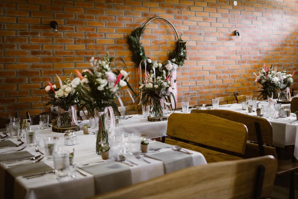 un conjunto de mesas con manteles y flores blancas en Wczasy od Maluszka do Staruszka, en Ryglice