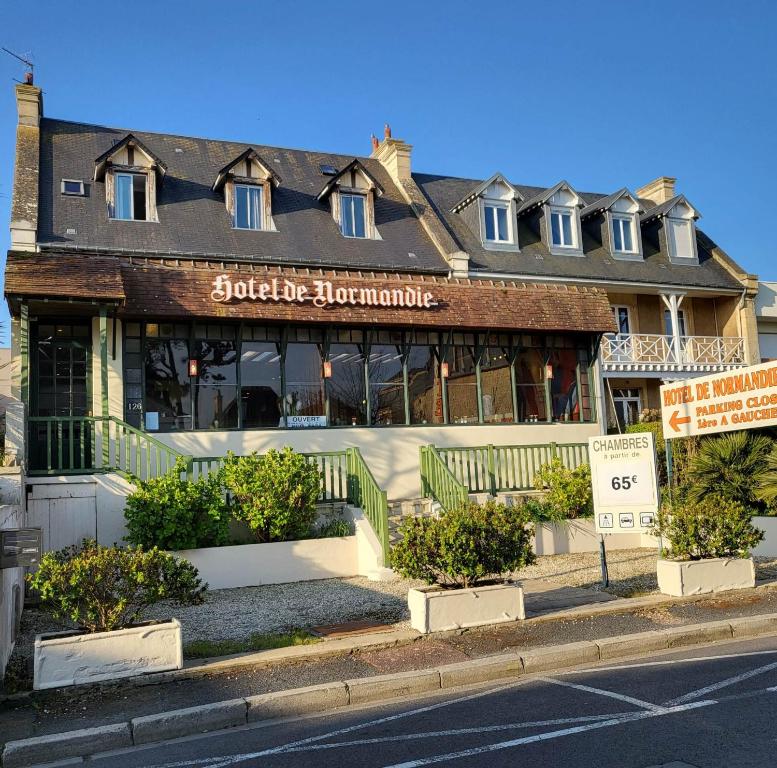 een gebouw aan de straatkant bij Hotel de Normandie in Saint-Aubin-sur-Mer