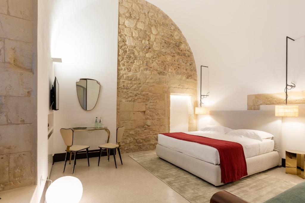 1 dormitorio con 1 cama, mesa y sillas en Palazzo De Noha - Boutique Hotel, en Lecce