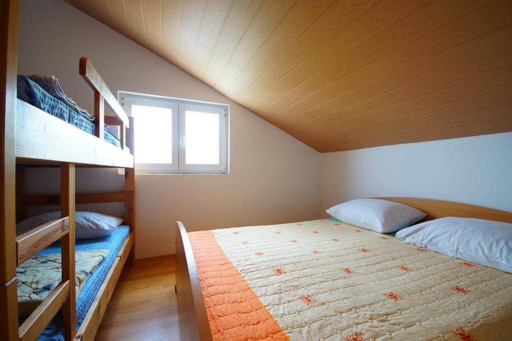 a bedroom with two bunk beds and a window at Apartmani Branka in Rtina