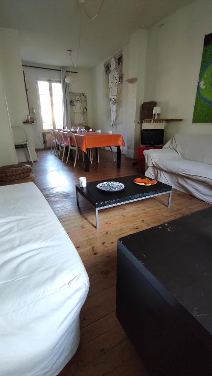 Cette chambre comprend 2 lits et une table. dans l'établissement Grande maison ancienne simple et spacieuse., à Vichy