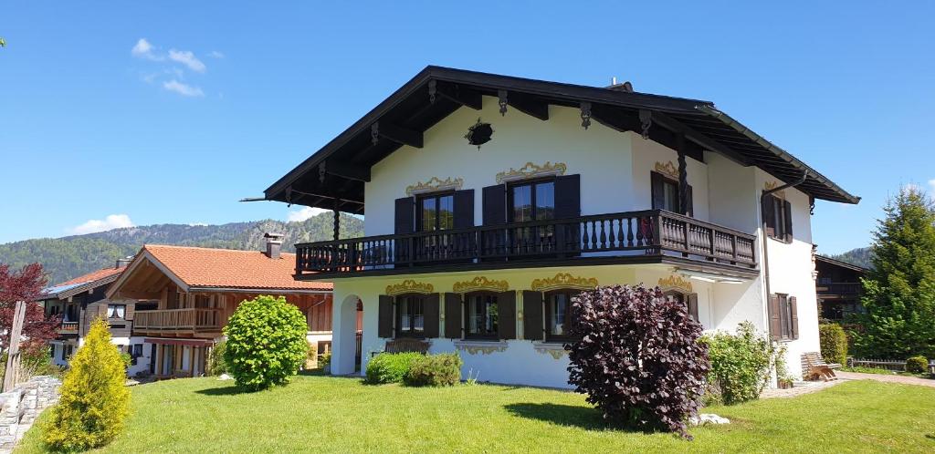 een groot wit huis met een balkon bij Haus Blindauer Eck in Reit im Winkl
