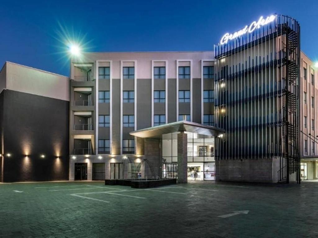 un edificio con un estacionamiento delante de él en The Grand Aria Hotel and Conference Centre, en Gaborone