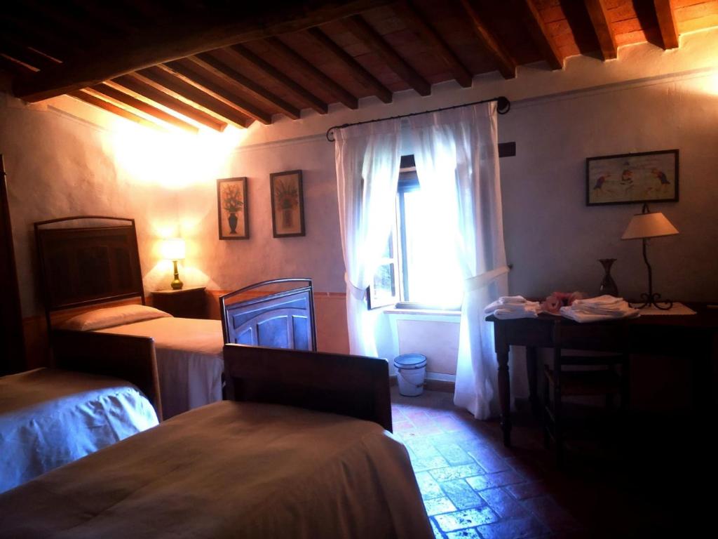 Un dormitorio con dos camas y una ventana. en Podere Poggio Lupinaio, en San Martino