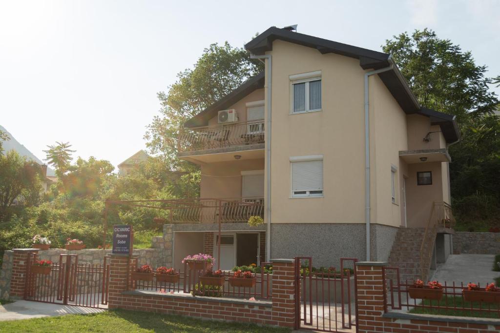 a house with a fence in front of it at Cicvaric rooms in Virpazar