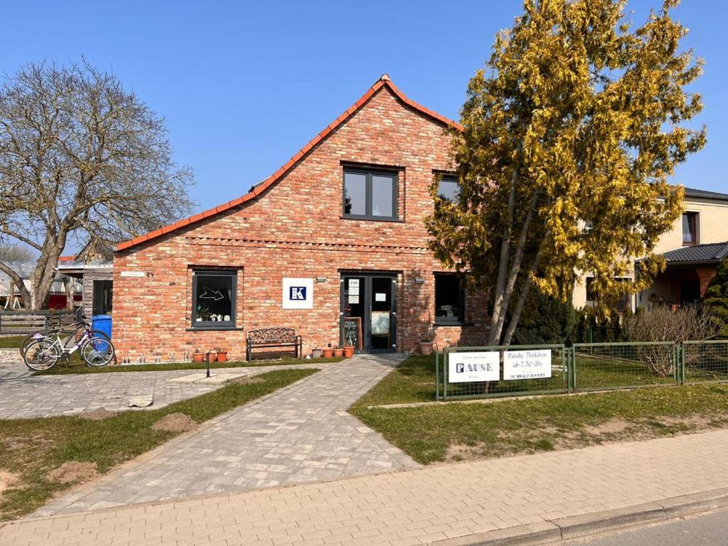 une maison en briques avec un panneau devant elle dans l'établissement Zierow Ostsee, à Zierow