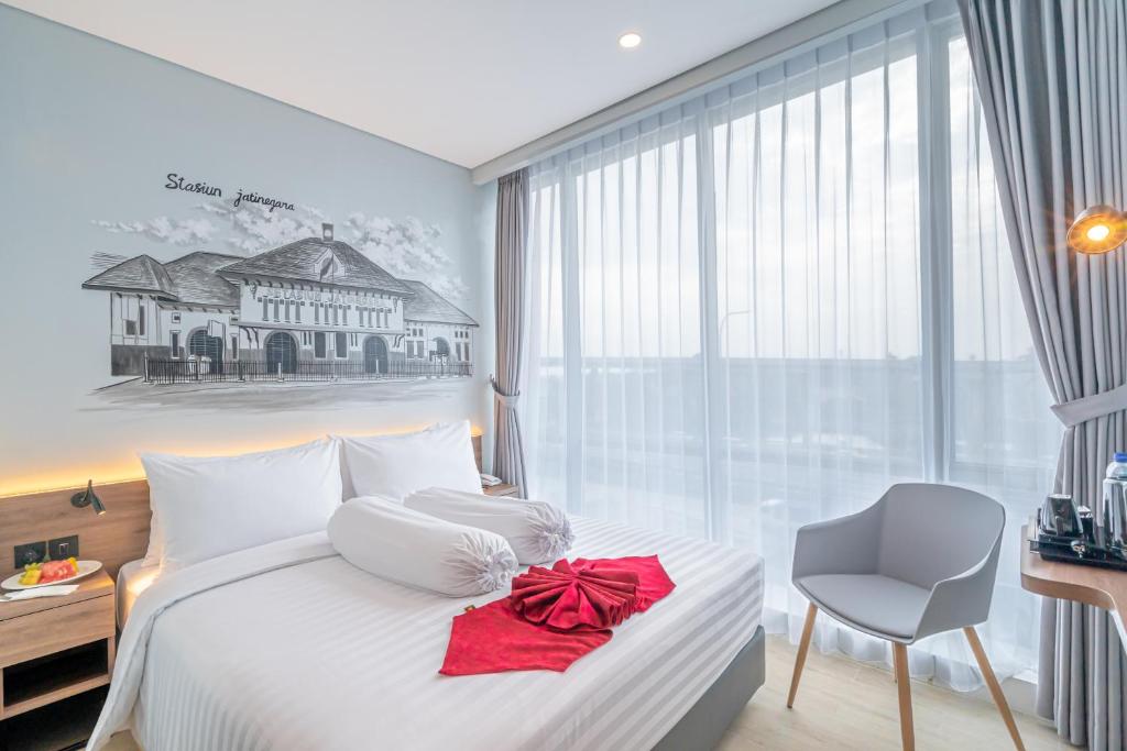 1 dormitorio con 1 cama con arco rojo en Azana Style Hotel Bandara Jakarta en Tangerang