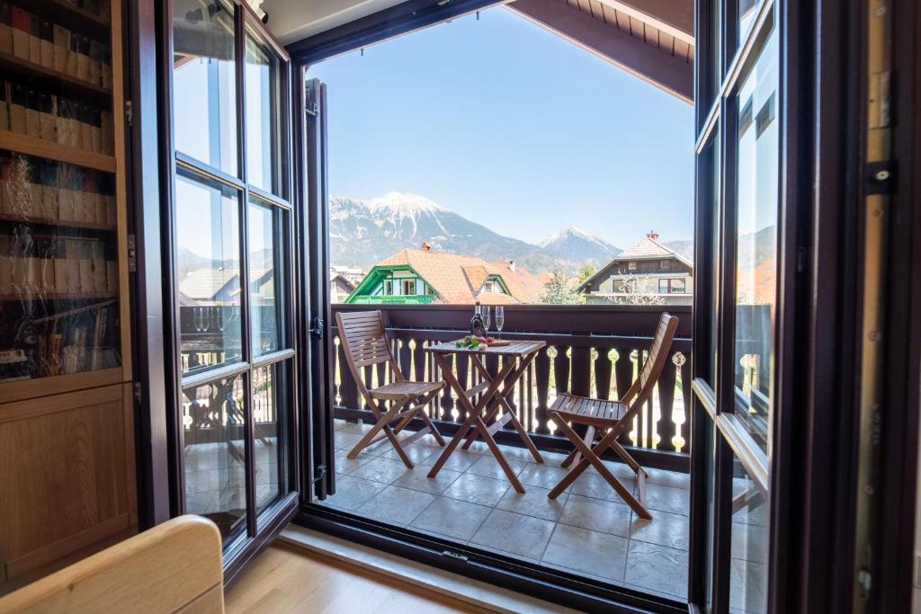 a room with a balcony with a table and chairs at Pleasant Apartments in Bled