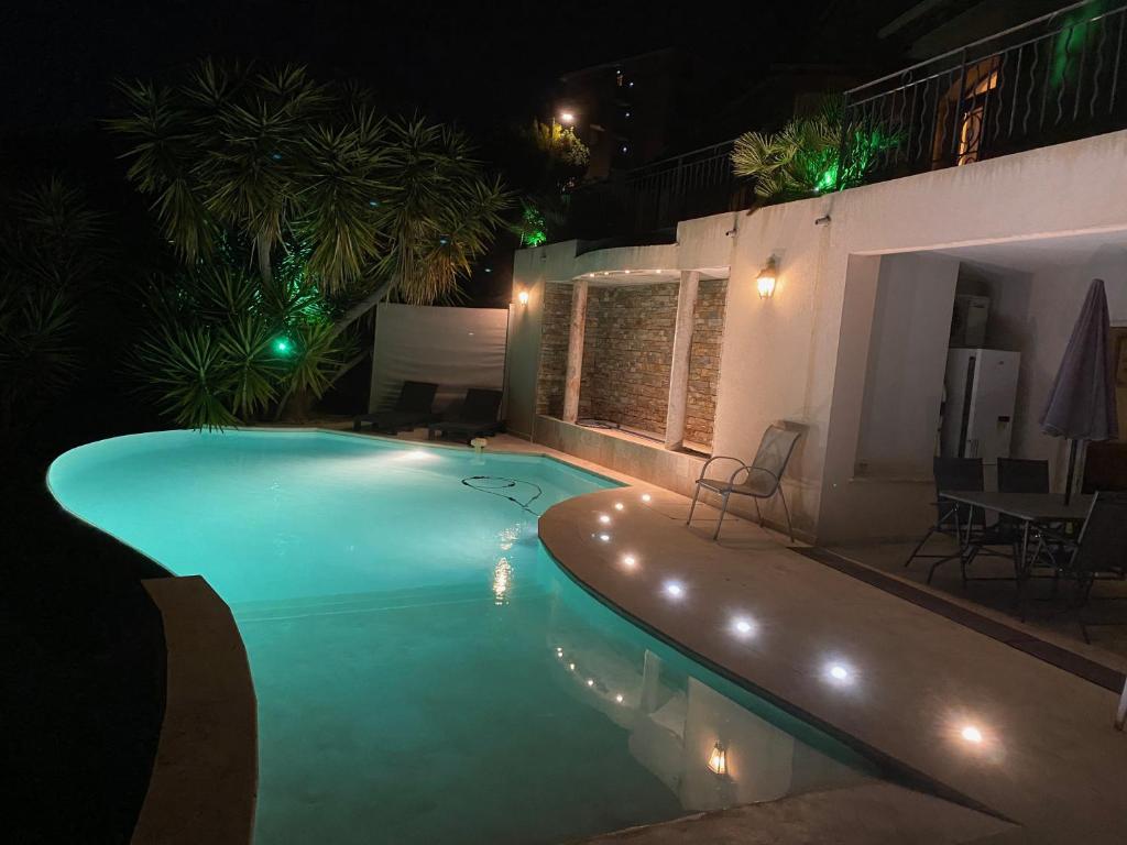ein Schwimmbad in der Nacht mit Lichtern in einem Haus in der Unterkunft Villa l'Olivier in Cagnes-sur-Mer