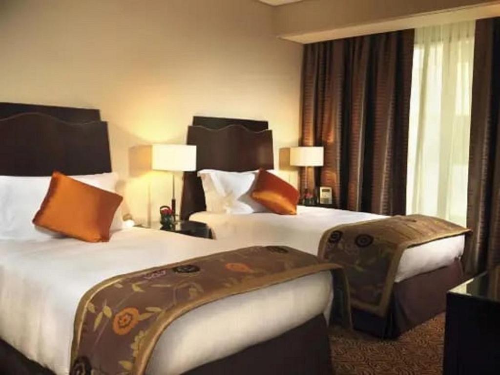 a hotel room with two beds with orange pillows at Town View Hotel in Cairo