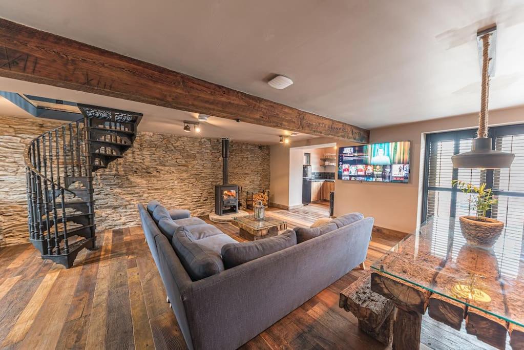 a living room with a couch and a stone wall at Luxury barn, newly renovated with river views in Staveley