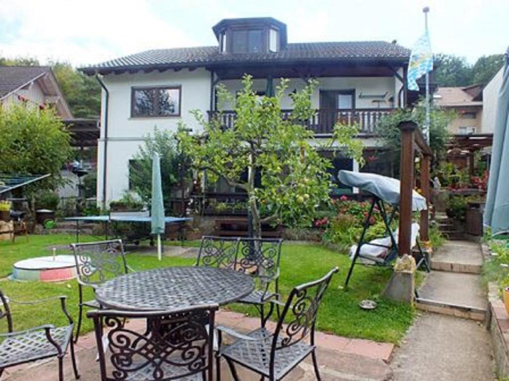 een patio met een tafel en stoelen en een huis bij Haus Schipper am Wald in Gemünden