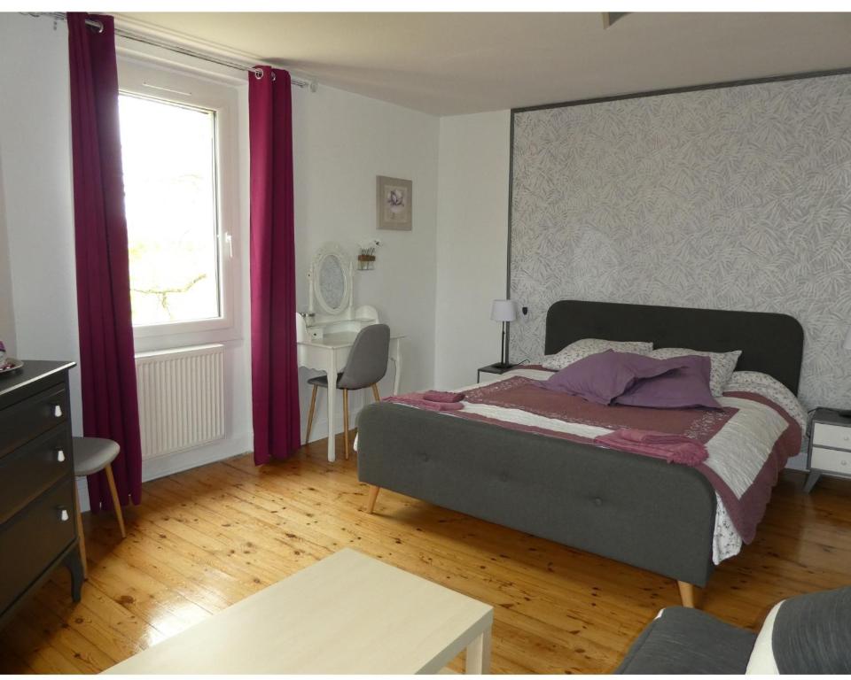 een slaapkamer met een bed met paarse gordijnen en een bureau bij Chambres d'Hôtes La Vigneronne in Senouillac