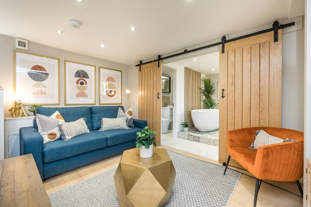 een woonkamer met een blauwe bank en een stoel bij Host & Stay - The Georgian Coach House 1 in Liverpool