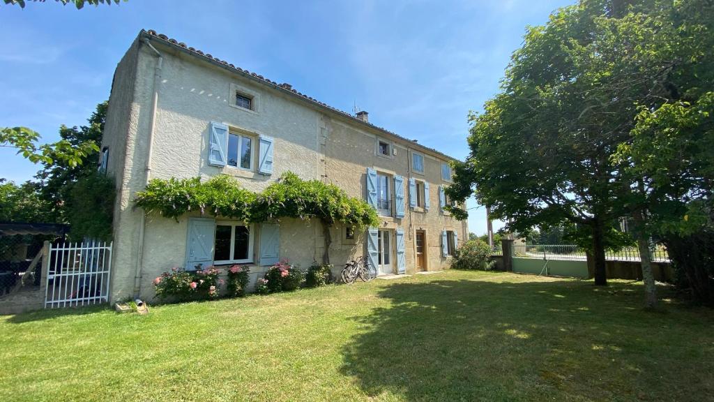 una casa grande con un patio delante en Gîte La Maison de Bosc en Coutens