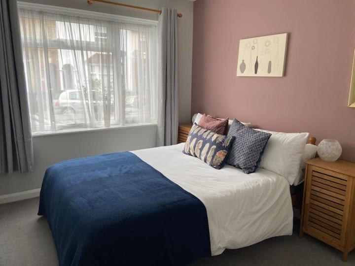 a bedroom with a bed with pillows and a window at The Seagull, with driveway and patio garden in Whitstable