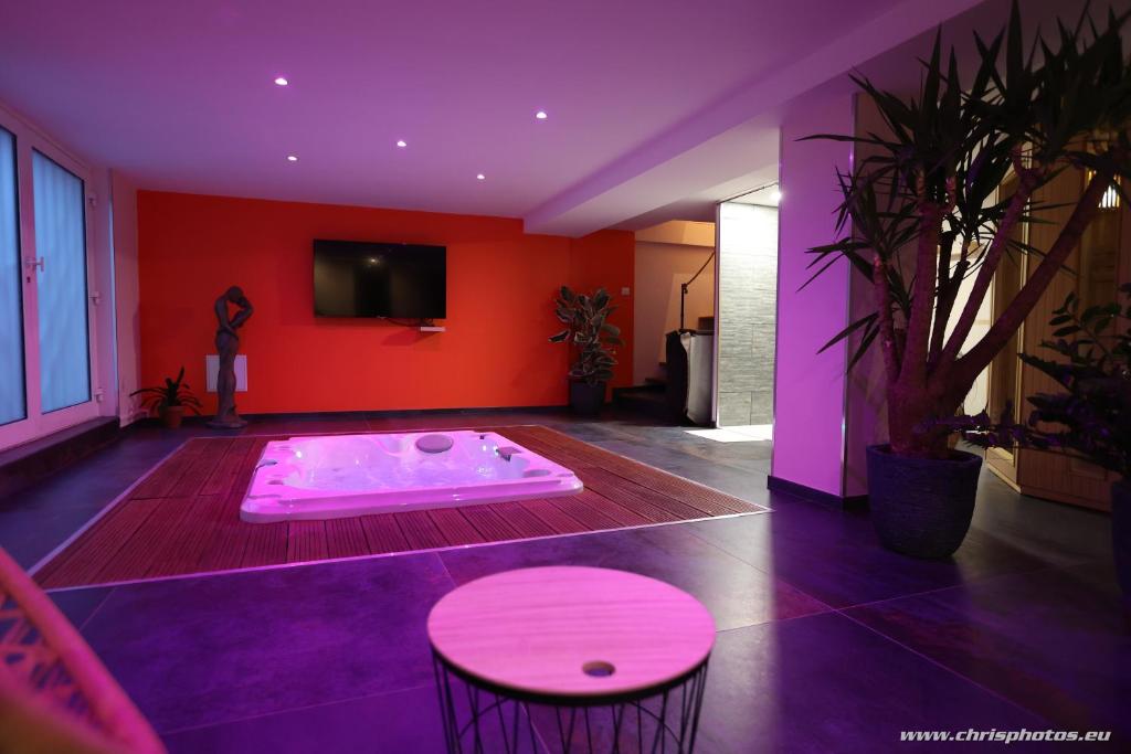a room with a hot tub with a table and chairs at Ds Plaisir Love Room avec sauna, jacuzzi à Nancy in Nancy