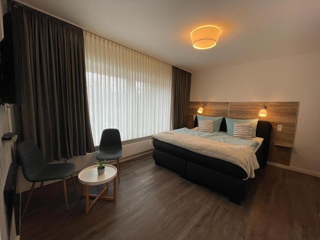 クックスハーフェンにあるHotel Deutsches Hausのベッドと椅子付きのホテルルーム