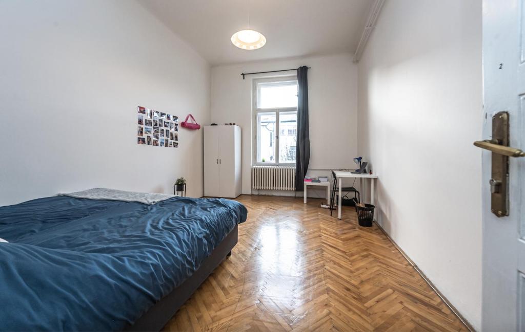 sypialnia z łóżkiem, biurkiem i oknem w obiekcie Legerova Apartments w Pradze