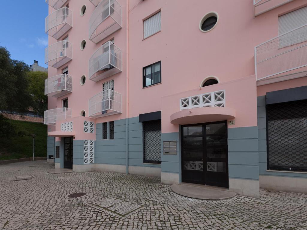 um edifício cor-de-rosa com um pátio em FLH Olivais Family Flat em Lisboa