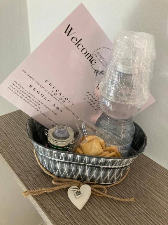 einen Geschenkkorb mit einer Schachtel und einer Flasche Wasser in der Unterkunft POMPEI FELIX in Pompei