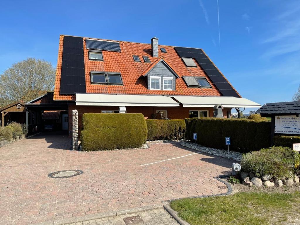 a house with an orange roof and a brick driveway at Fehmarn-OstseeferienFewoAnders11591 in Neue Tiefe Fehmarn