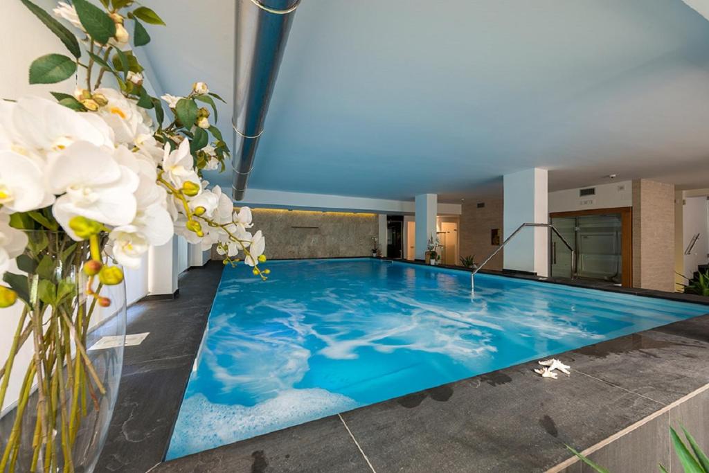 a swimming pool in a building with flowers at Zenit Hotel in Giulianova
