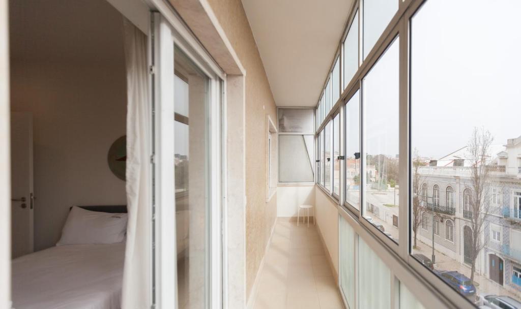 um quarto com uma cama e uma grande janela em FLH Estefânia Charming Flat em Lisboa