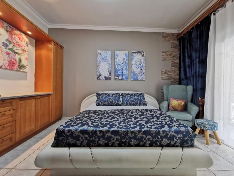 een slaapkamer met een bed en een stoel bij Villa Anna in Limenas