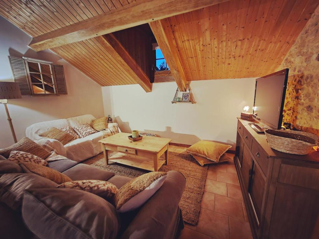 a living room with a couch and a table at La Ferme de Philomène - Gîte en Périgord Noir in Sainte-Foy-de-Belvès