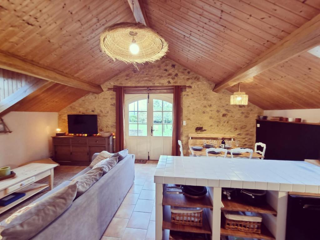 a living room with a couch and a table at La Ferme de Philomène - Gîte en Périgord Noir in Sainte-Foy-de-Belvès