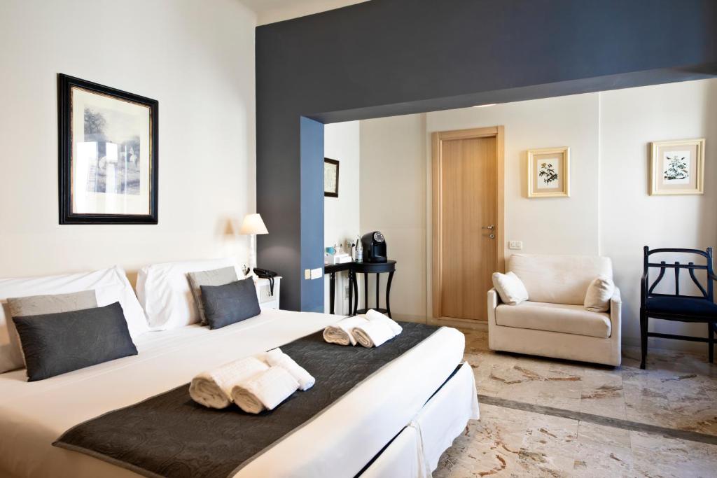 una habitación de hotel con una cama grande y una silla en Hotel Broletto, en Mantua