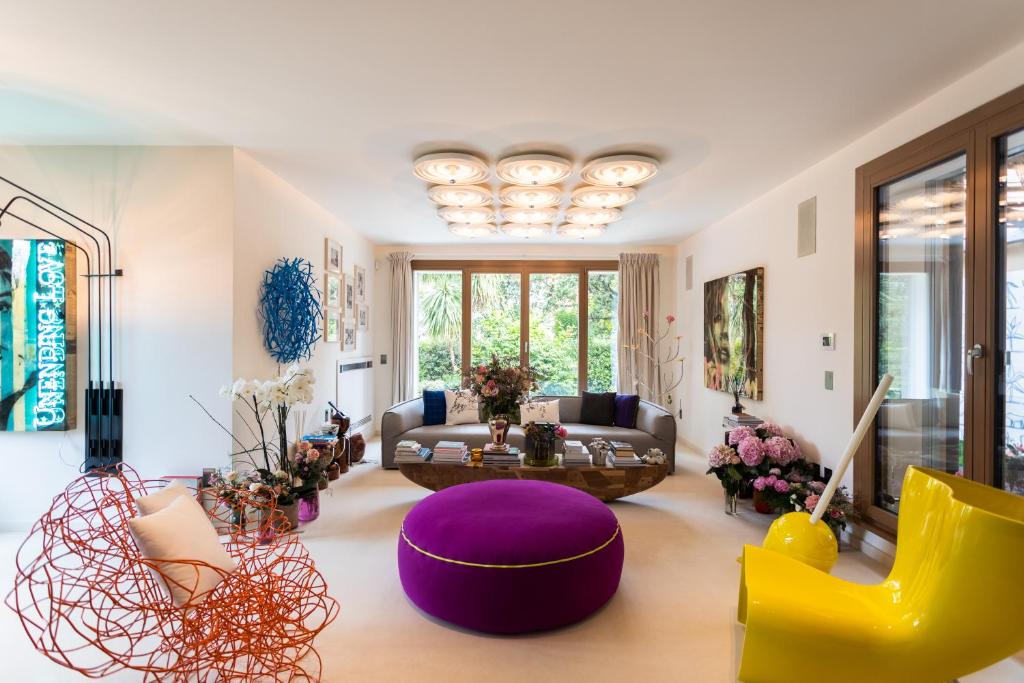 a living room with a purple couch and yellow chairs at The Magic Forte in Forte dei Marmi