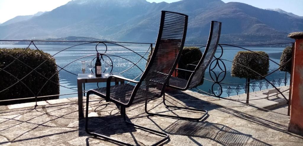 een tafel en stoel op een balkon met uitzicht op het water bij My Holidays - La Terrazza sul Lago in Gravedona