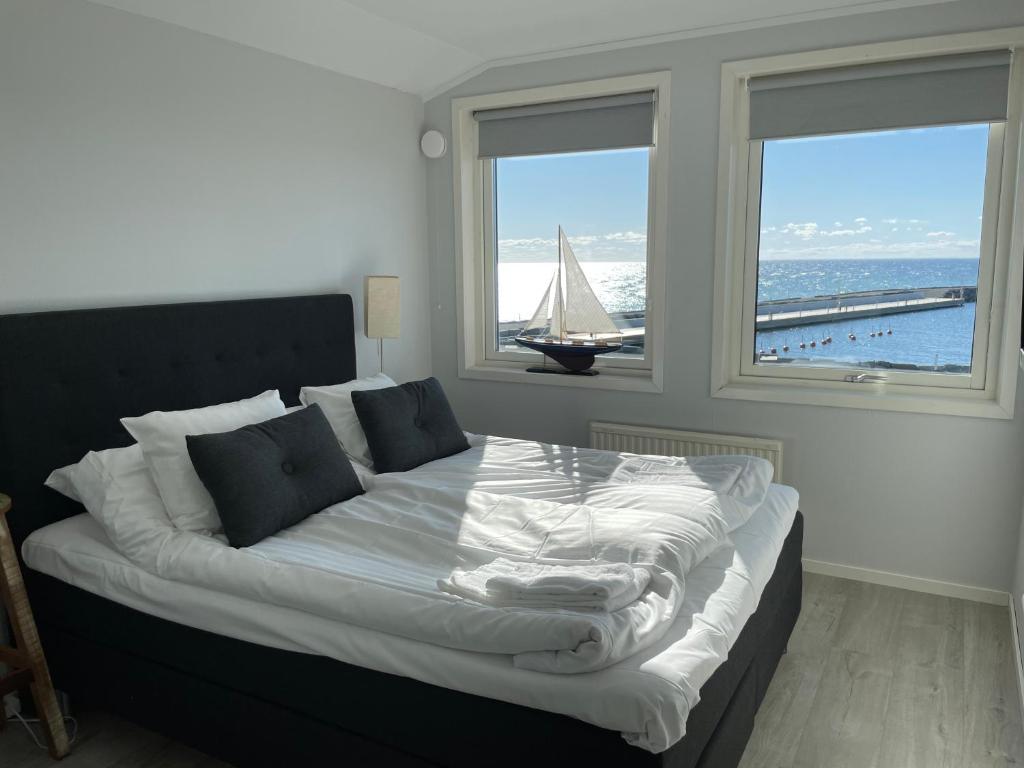 1 dormitorio con 1 cama grande y un velero en la ventana en Byxelkroks Marina Sea Resort, en Byxelkrok
