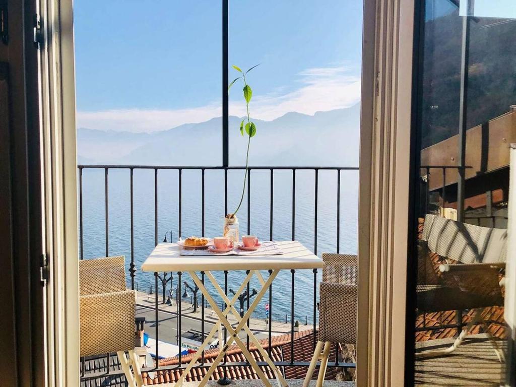 a table on a balcony with a view of the ocean at Cà Milla Argegno apartment in Argegno