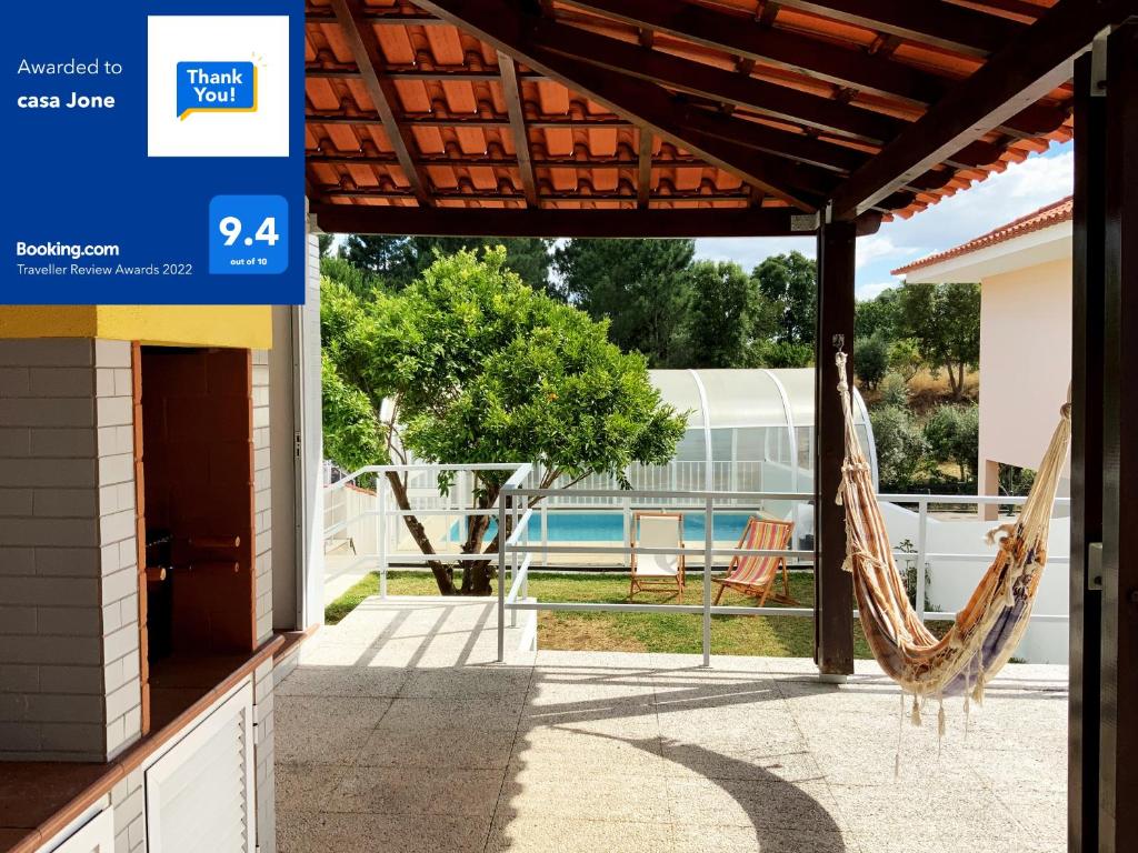 a patio with a hammock and a swimming pool at casa Jone in Tomar