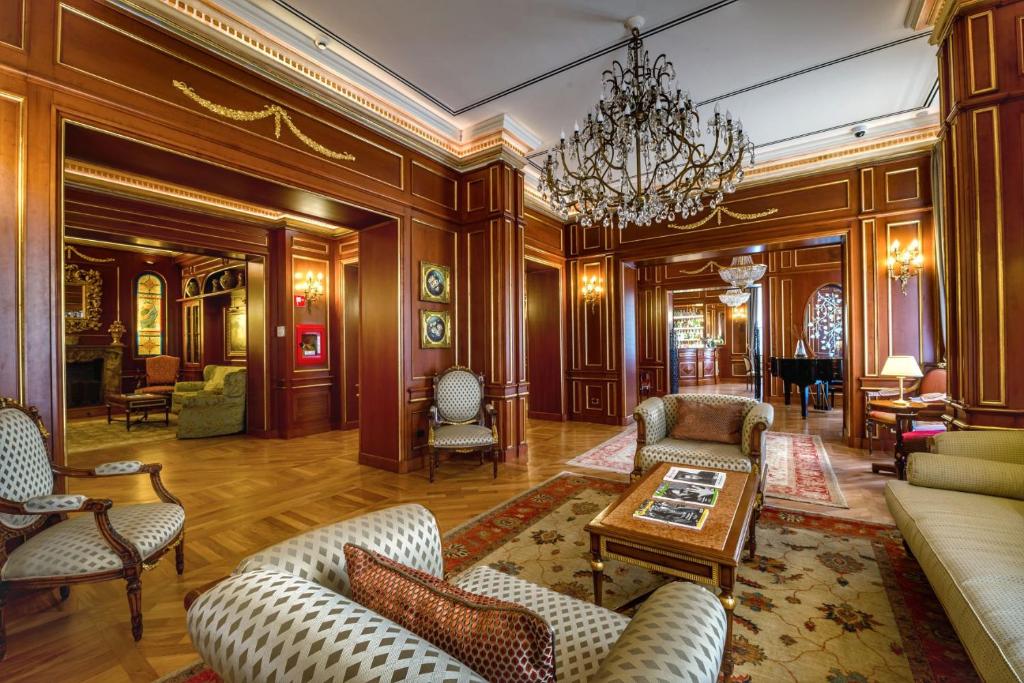 een woonkamer met meubilair en een kroonluchter bij Grand Hotel Wagner in Palermo