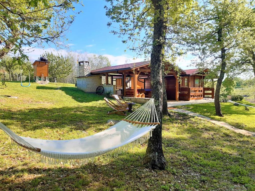 a hammock in front of a log cabin at Robinson House Istra Vižinada Poreč in Vižinada